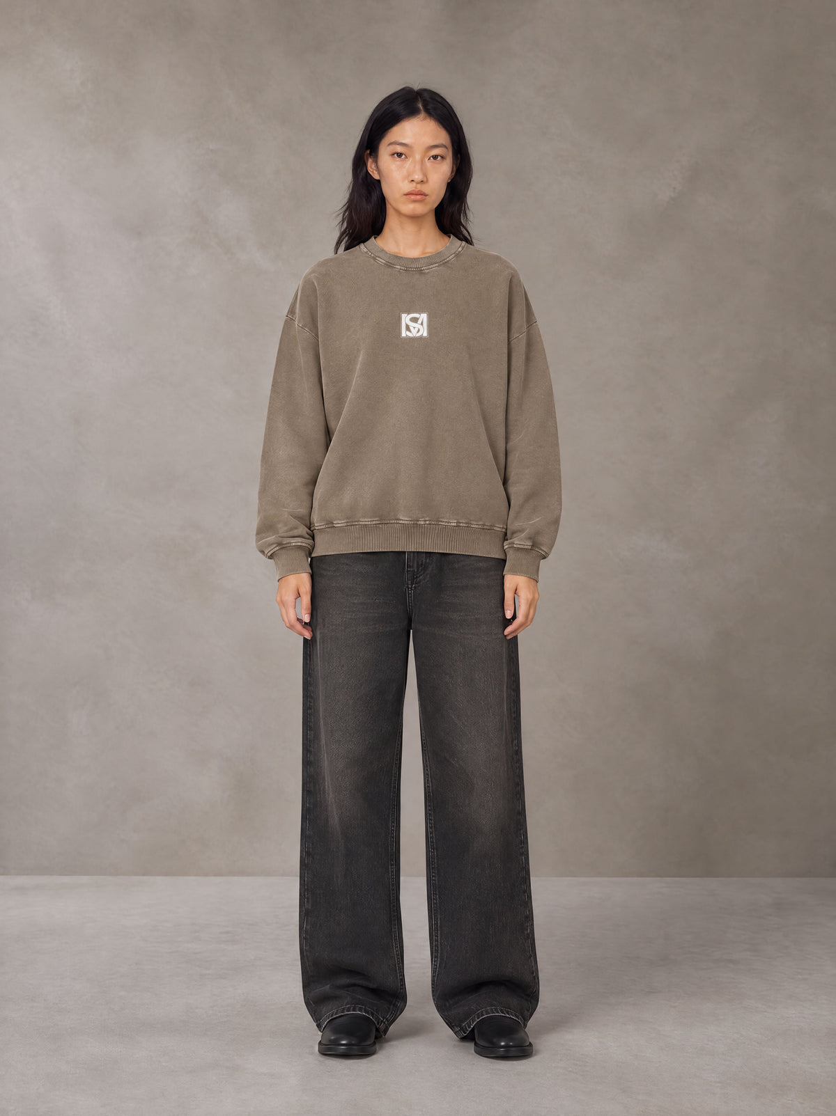 Model wearing the SM Acid Wash Sweatshirt in Coffee Grey, front view.