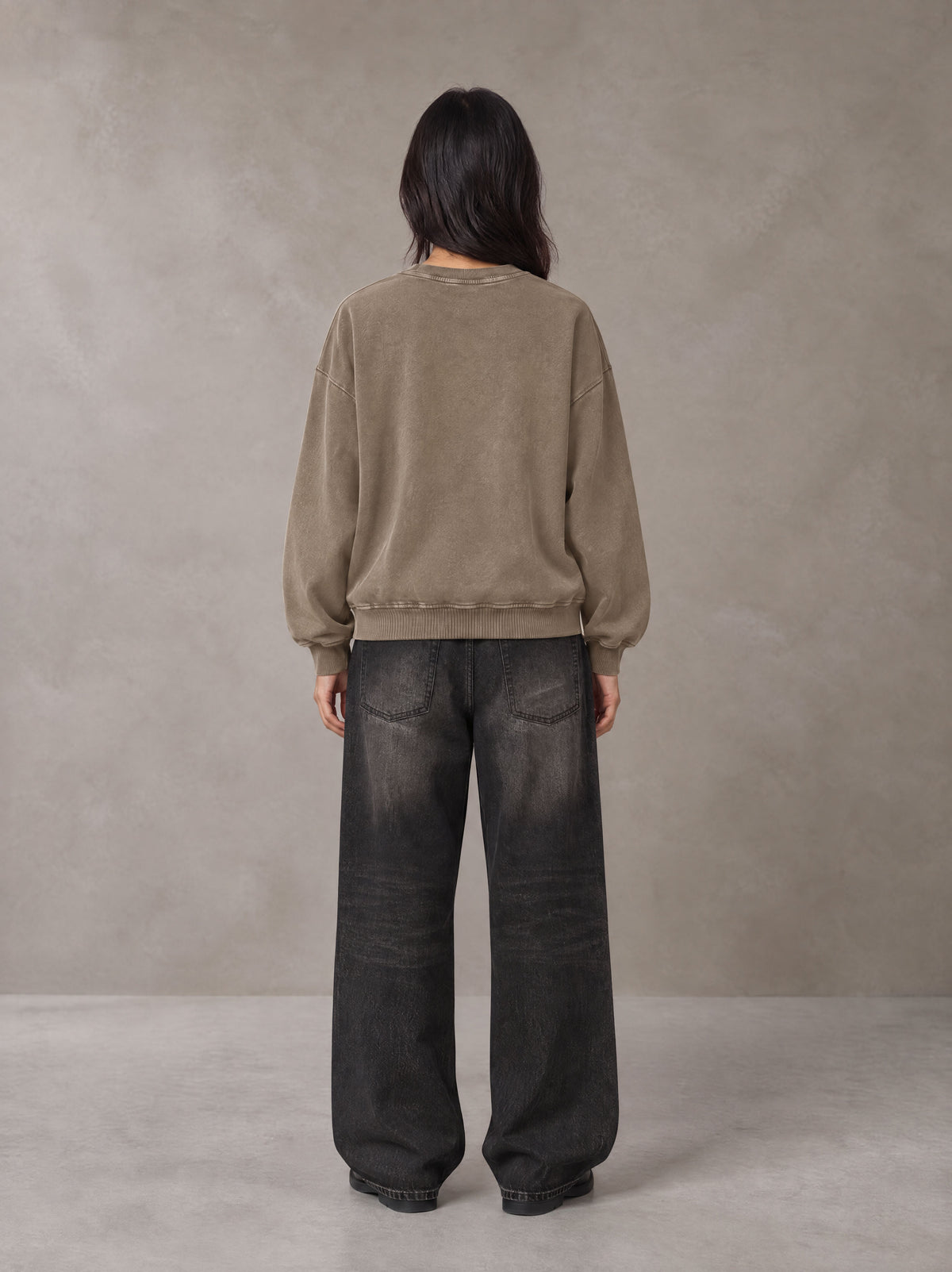Model wearing the SM Acid Wash Sweatshirt in Coffee Grey, rear view.