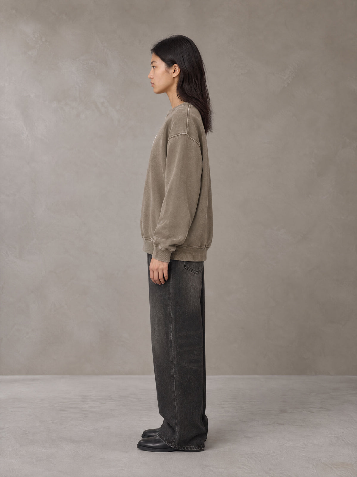 Model wearing the SM Acid Wash Sweatshirt in Coffee Grey, side profile.