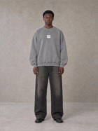 Model wearing the SM Acid Wash Sweatshirt in Pure Grey, front view.