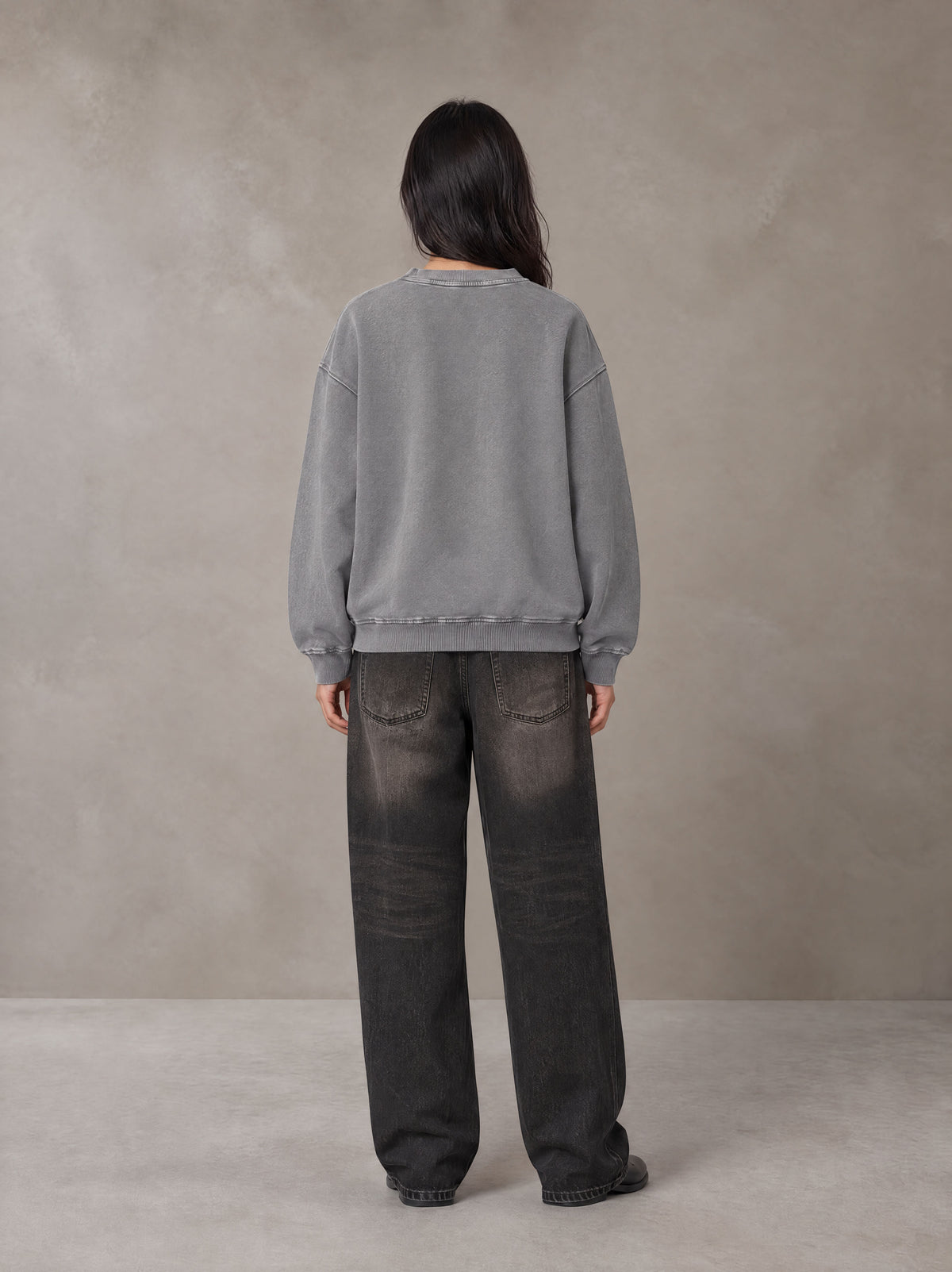 Model wearing the SM Acid Wash Sweatshirt in Pure Grey, rear view.