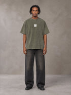 Model wearing the SM Acid Wash T-shirt in Alpine Green, front view.