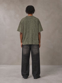 Model wearing the SM Acid Wash T-shirt in Alpine Green, rear view.