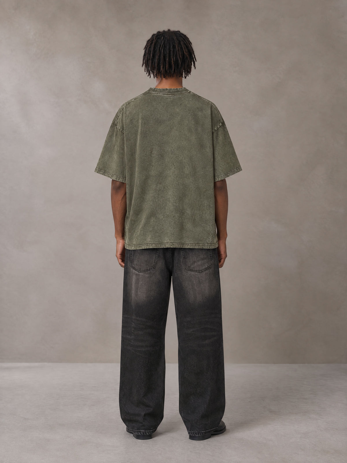 Model wearing the SM Acid Wash T-shirt in Alpine Green, rear view.