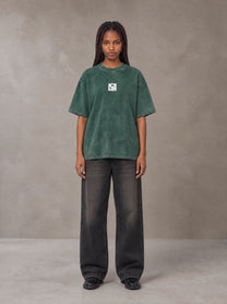 Model wearing the SM Acid Wash T-shirt in Dark Green, front view.