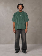 Model wearing the SM Acid Wash T-shirt in Dark Green, front view.