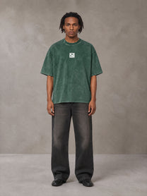 Model wearing the SM Acid Wash T-shirt in Dark Green, front view.