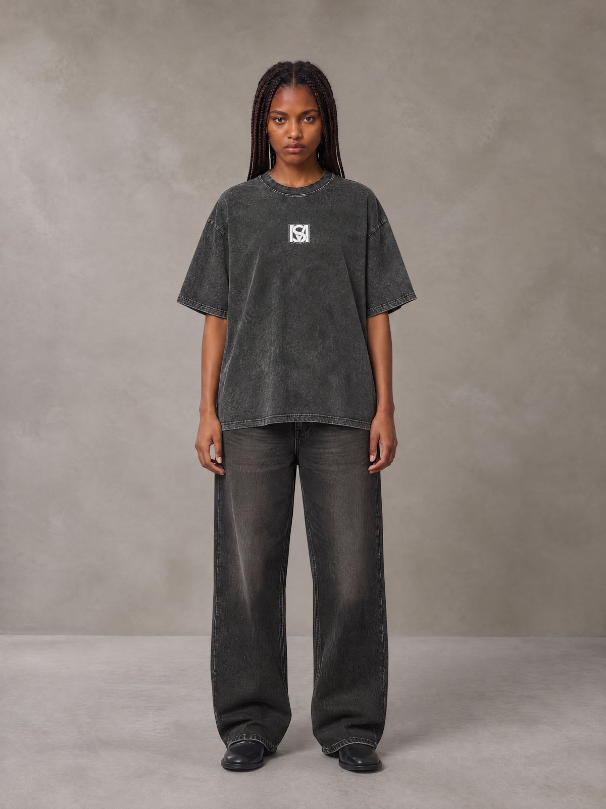 Model wearing the SM Acid Wash T-shirt in Deep Charcoal, front view.