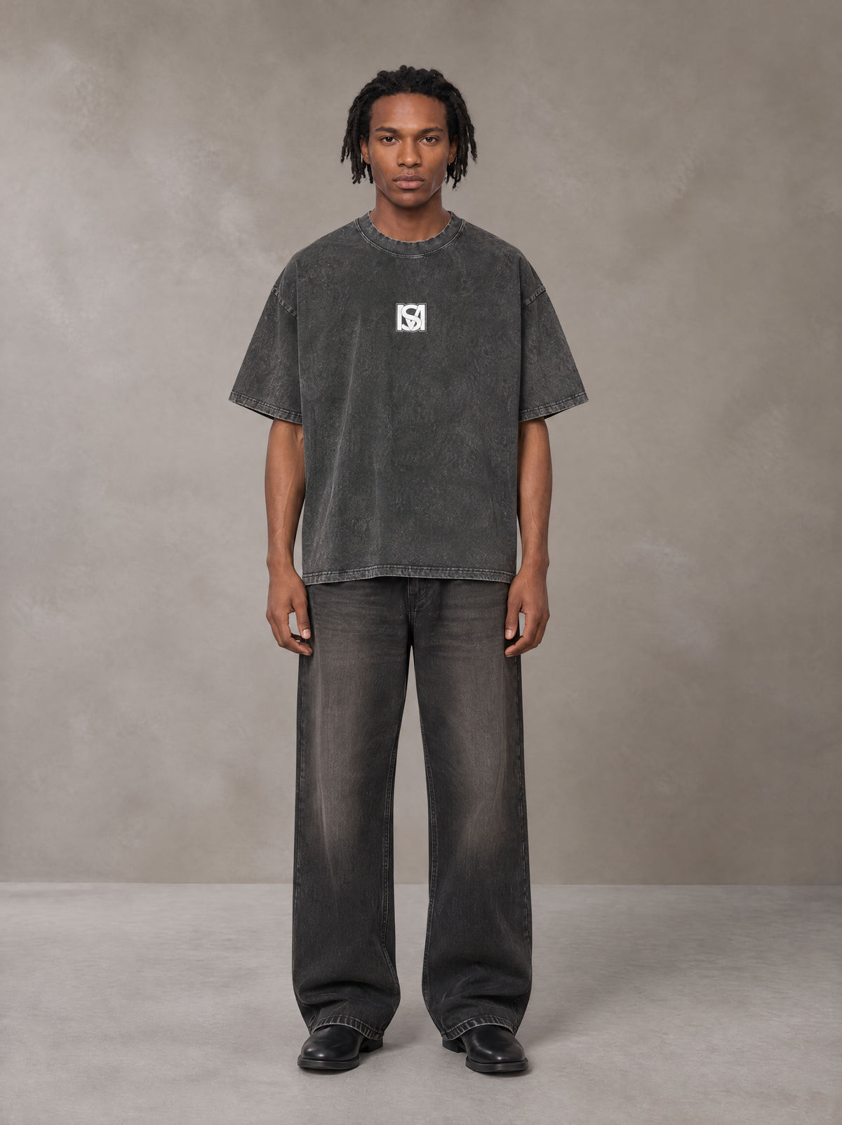 Model wearing the SM Acid Wash T-shirt in Deep Charcoal, front view.