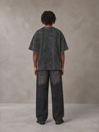 Model wearing the SM Acid Wash T-shirt in Deep Charcoal, rear view.
