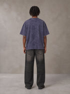 Model wearing the SM Acid Wash T-shirt in Deep Purple, rear view.