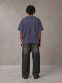 Model wearing the SM Acid Wash T-shirt in Deep Purple, rear view.