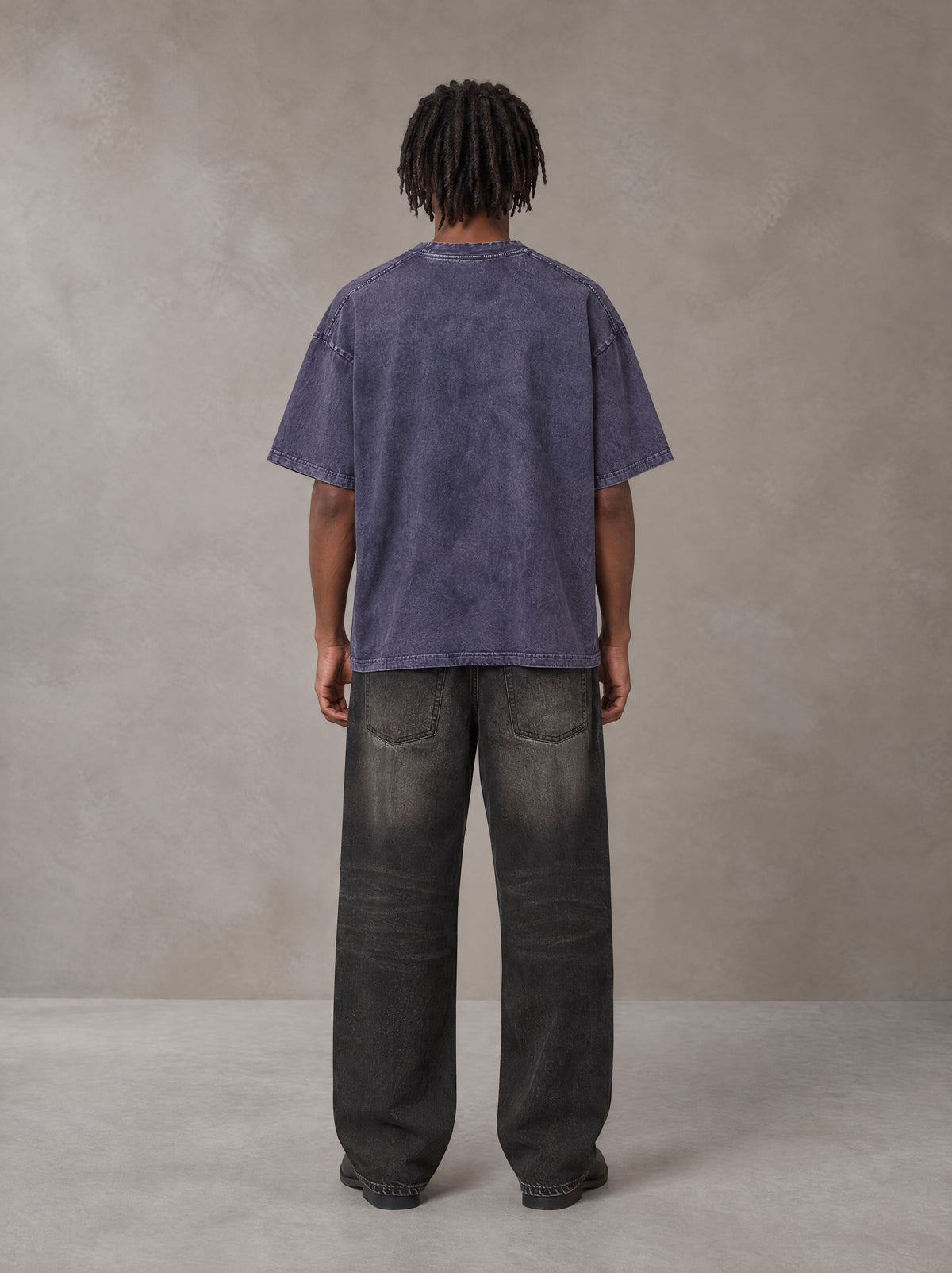 Model wearing the SM Acid Wash T-shirt in Deep Purple, rear view.