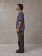 Model wearing the SM Acid Wash T-shirt in Deep Purple, side profile.