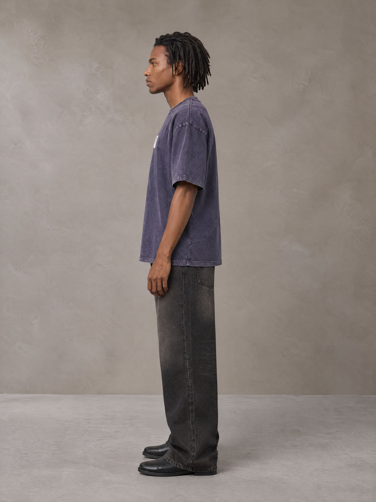 Model wearing the SM Acid Wash T-shirt in Deep Purple, side profile.