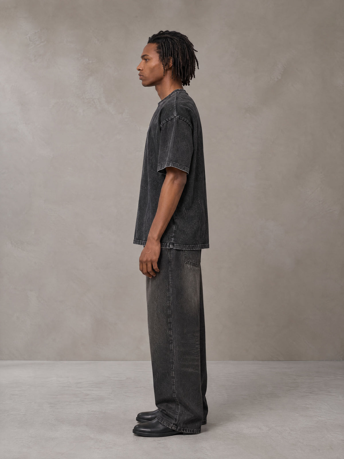 Model wearing the SM Acid Wash T-shirt in Midnight Black, side profile.