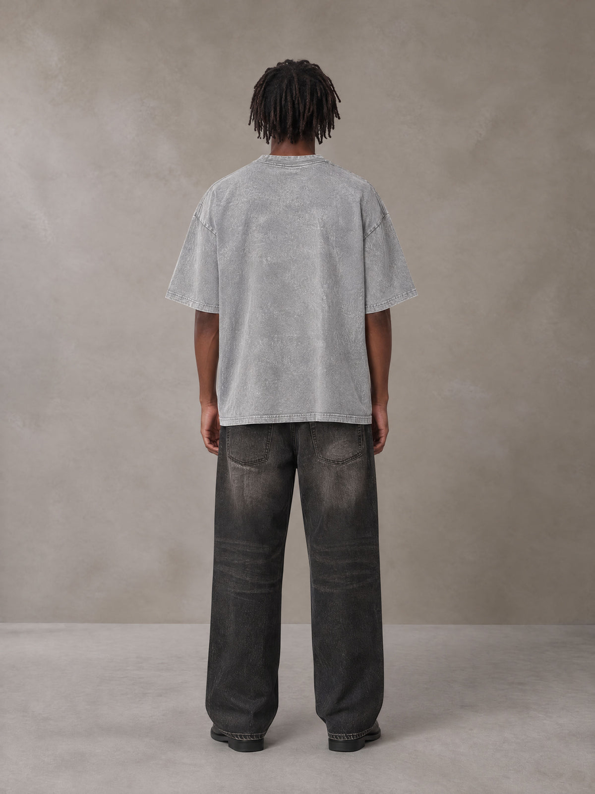 Model wearing the SM Acid Wash T-shirt in Pure Grey, rear view.