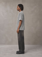 Model wearing the SM Acid Wash T-shirt in Pure Grey, side profile.