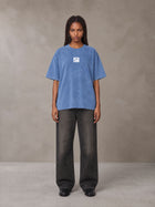 Model wearing the SM Acid Wash T-shirt in Soft Blue, front view.