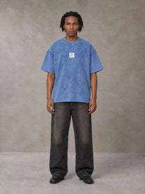 Model wearing the SM Acid Wash T-shirt in Soft Blue, front view.