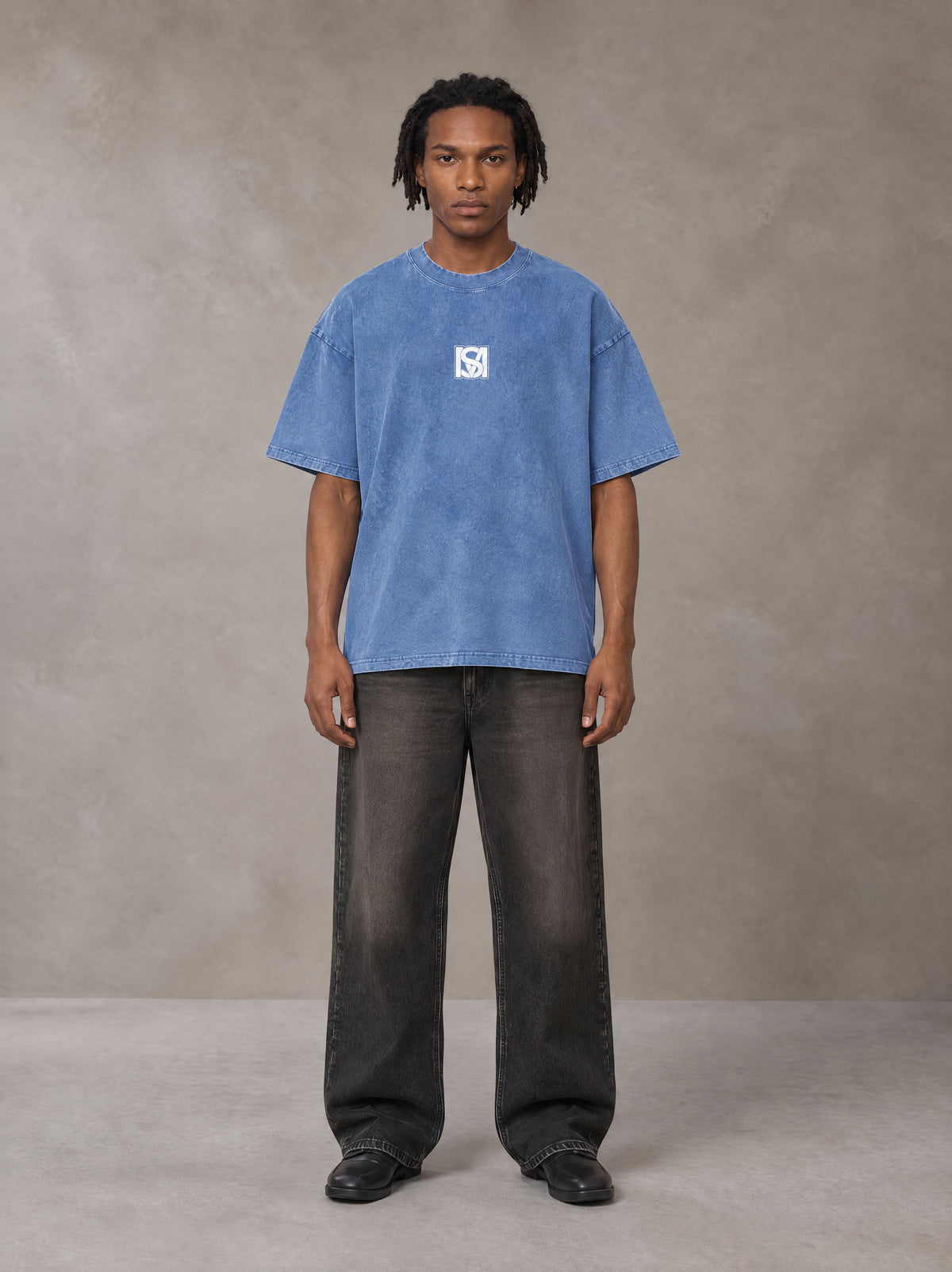 Model wearing the SM Acid Wash T-shirt in Soft Blue, front view.