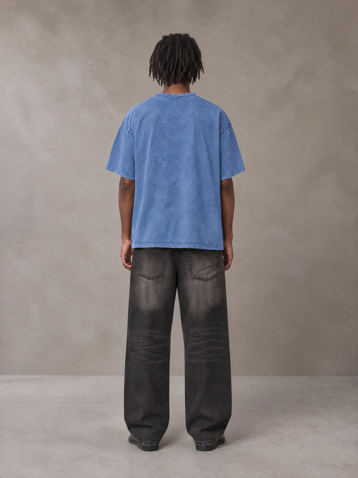 Model wearing the SM Acid Wash T-shirt in Soft Blue, rear view.