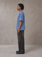Model wearing the SM Acid Wash T-shirt in Soft Blue, side profile.