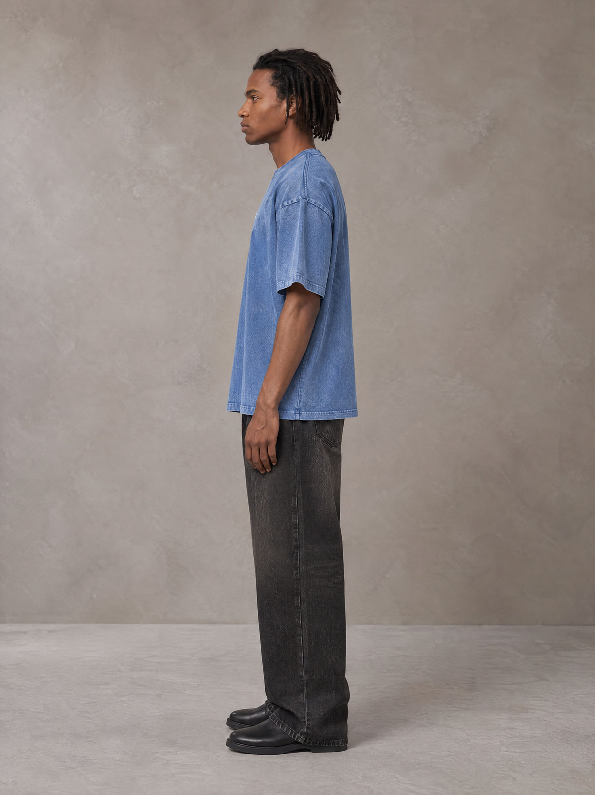 Model wearing the SM Acid Wash T-shirt in Soft Blue, side profile.