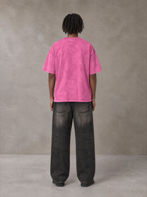 Model wearing the SM Acid Wash T-shirt in Vivid Pink, rear view.