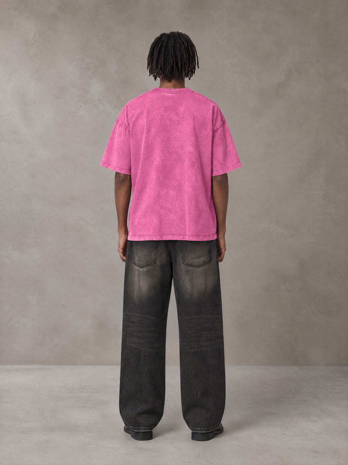 Model wearing the SM Acid Wash T-shirt in Vivid Pink, rear view.