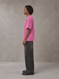 Model wearing the SM Acid Wash T-shirt in Vivid Pink, side profile.