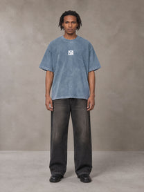 Model wearing the SM Acid Wash T-shirt in Washed Blue Jean, front view.