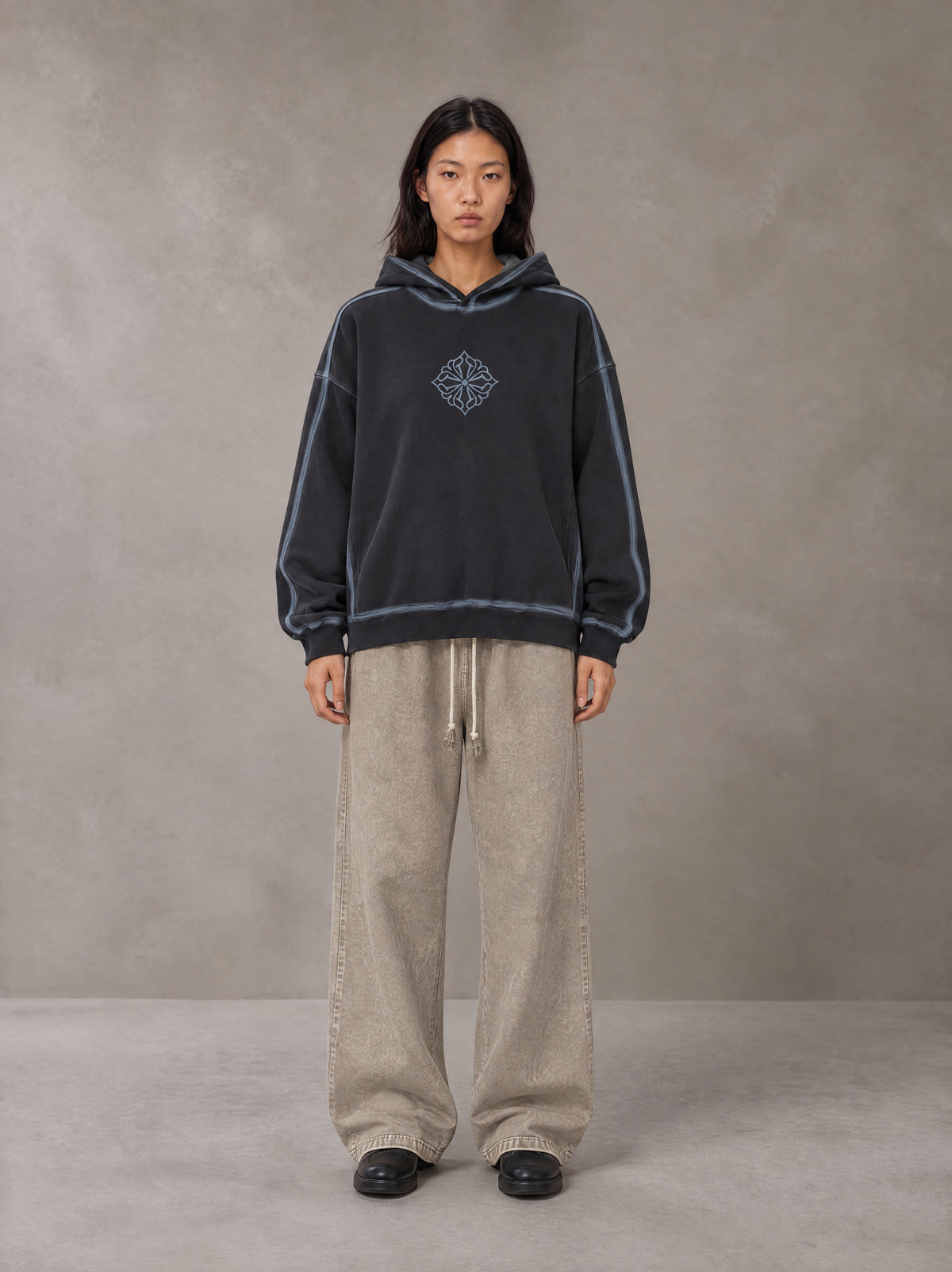 Model wearing the SM Acid Wash Trousers in Stone Grey, front view.