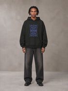 Model wearing the SM Baroque Bloom Hoodie in Midnight Black, front view.