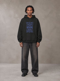 Model wearing the SM Baroque Bloom Hoodie in Midnight Black, front view.