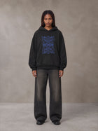 Model wearing the SM Baroque Bloom Hoodie in Midnight Black, front view.