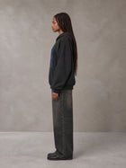 Model wearing the SM Baroque Bloom Hoodie in Midnight Black, side profile.