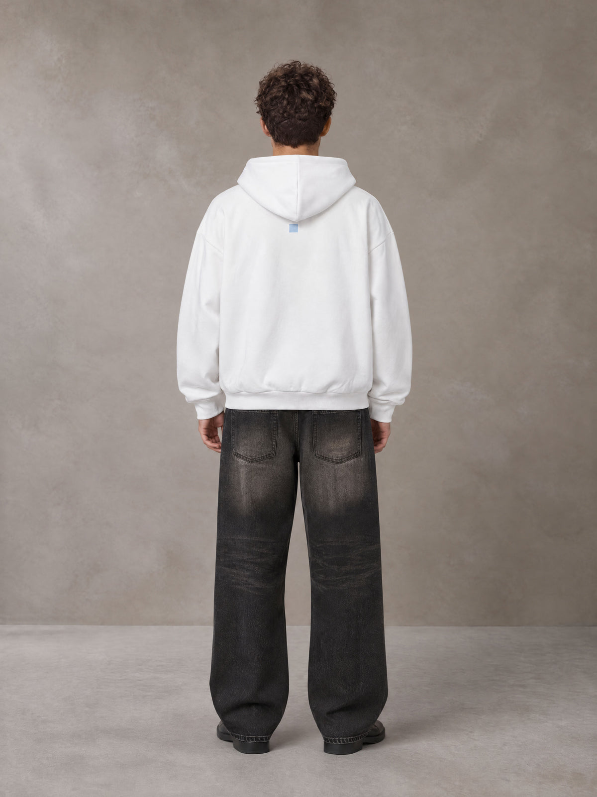 Model wearing the SM Baroque Bloom Hoodie in Lucent White, rear view.