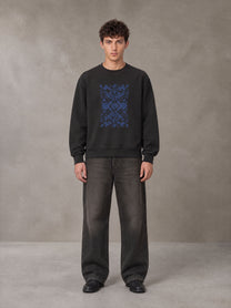 Model wearing the SM Baroque Bloom Sweatshirt in Midnight Black, front view.