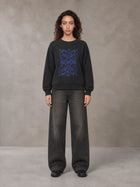 Model wearing the SM Baroque Bloom Sweatshirt in Midnight Black, front view.