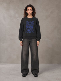 Model wearing the SM Baroque Bloom Sweatshirt in Midnight Black, front view.