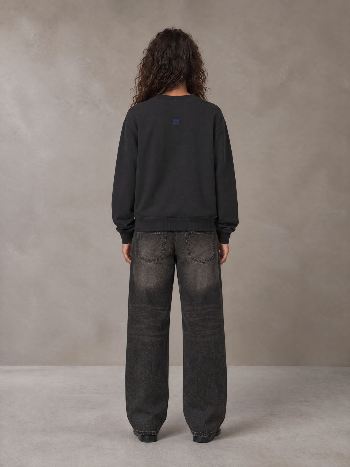 Model wearing the SM Baroque Bloom Sweatshirt in Midnight Black, rear view.