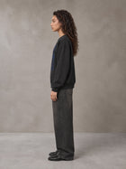 Model wearing the SM Baroque Bloom Sweatshirt in Midnight Black, side profile.