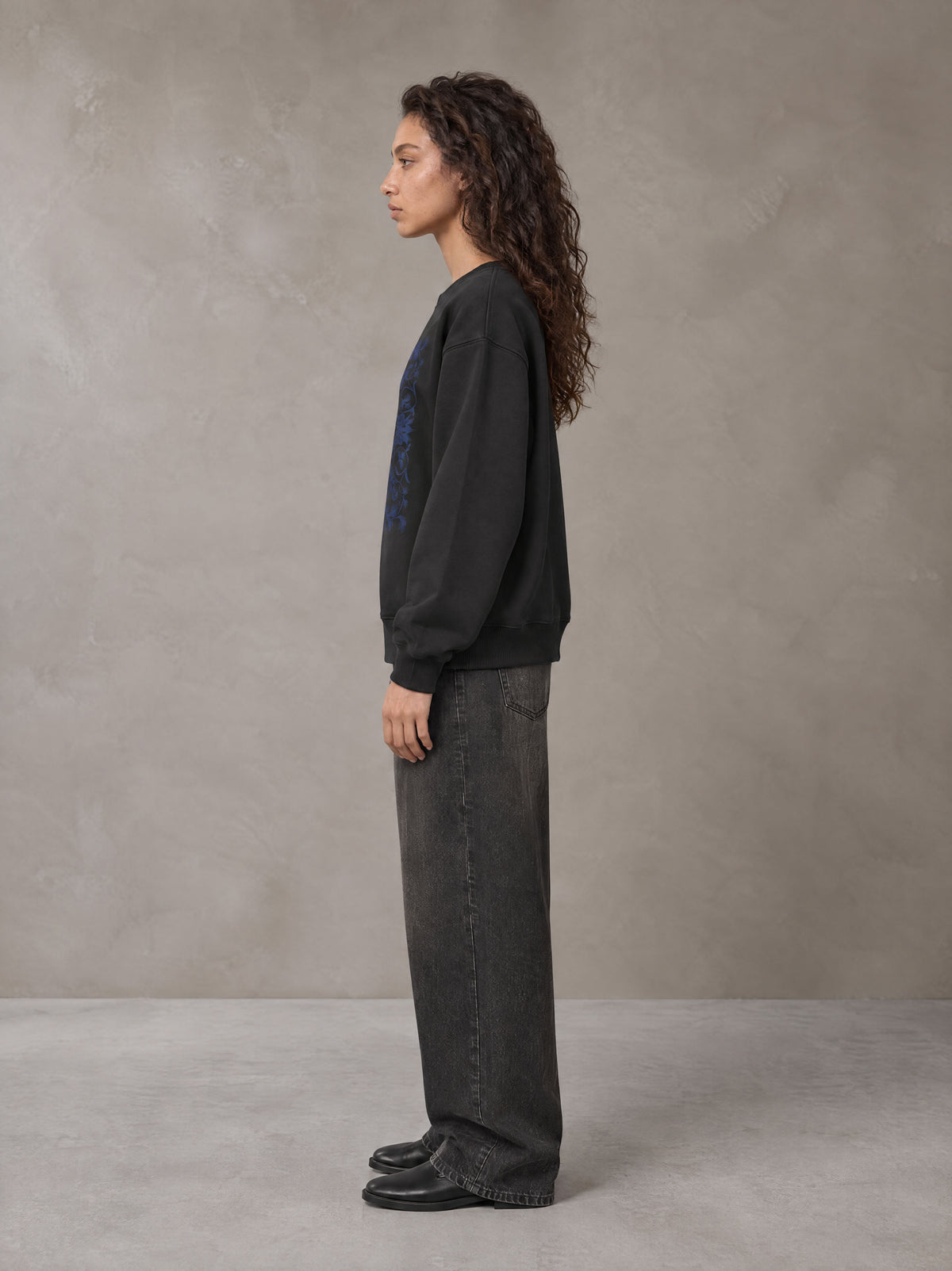 Model wearing the SM Baroque Bloom Sweatshirt in Midnight Black, side profile.