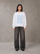 Model wearing the SM Baroque Bloom Sweatshirt in Lucent White, front view.