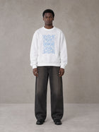 Model wearing the SM Baroque Bloom Sweatshirt in Lucent White, front view.