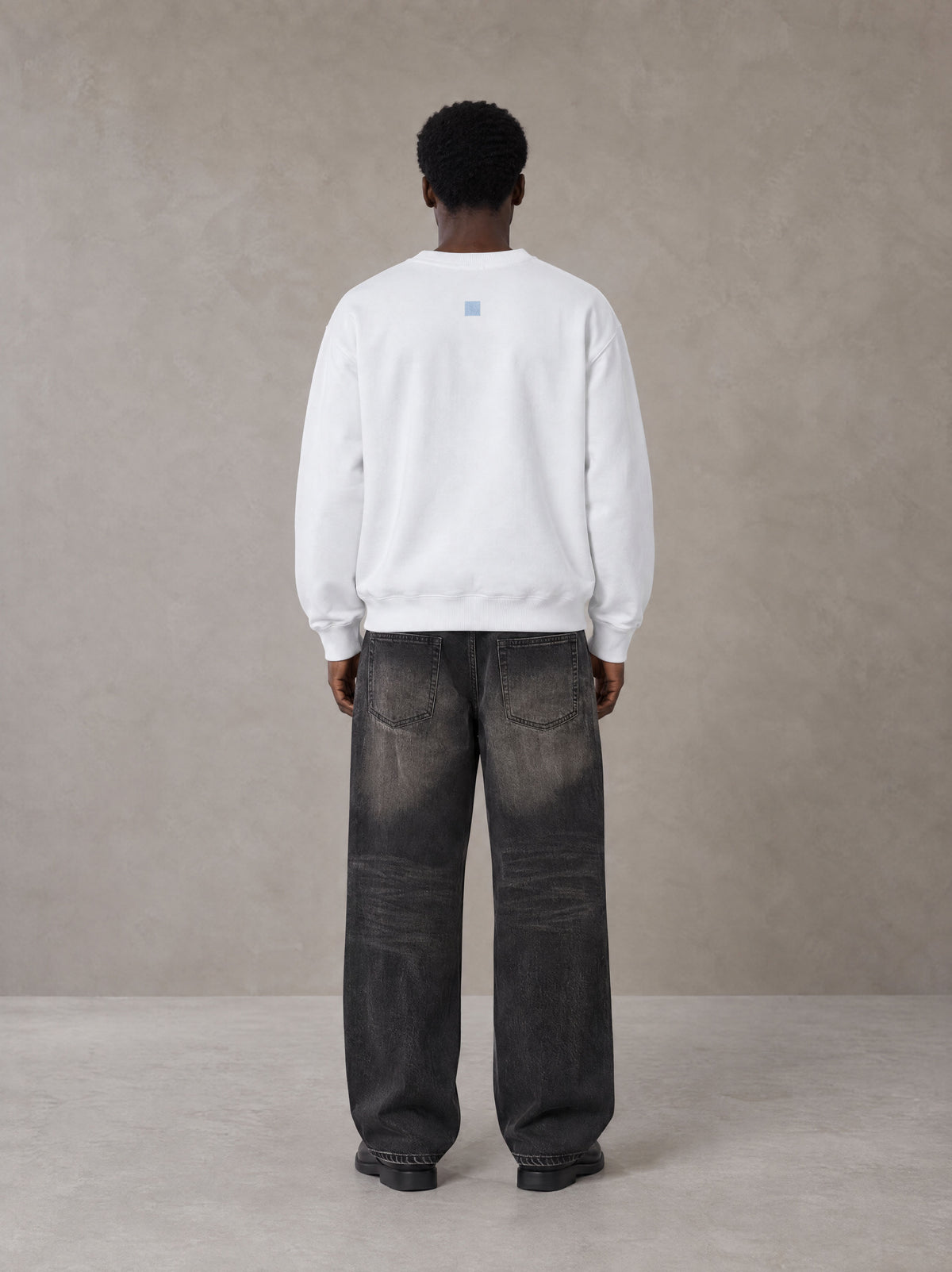 Model wearing the SM Baroque Bloom Sweatshirt in Lucent White, rear view.