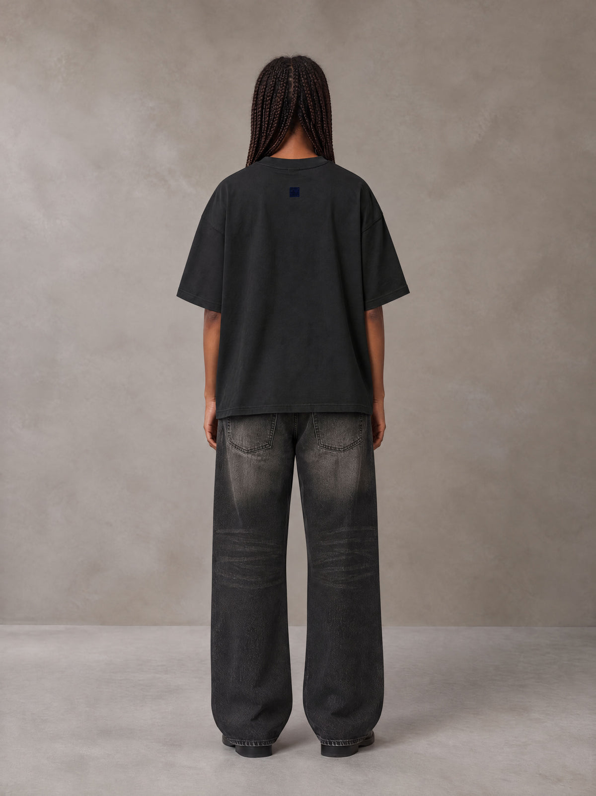 Model wearing the SM Baroque Bloom T-shirt in Midnight Black, rear view.