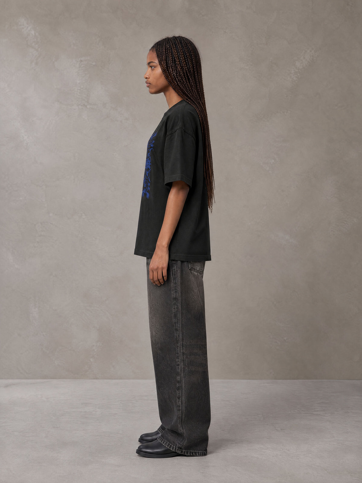 Model wearing the SM Baroque Bloom T-shirt in Midnight Black, side profile.