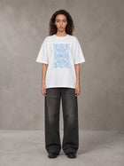 Model wearing the SM Baroque Bloom T-shirt in Lucent White, front view.
